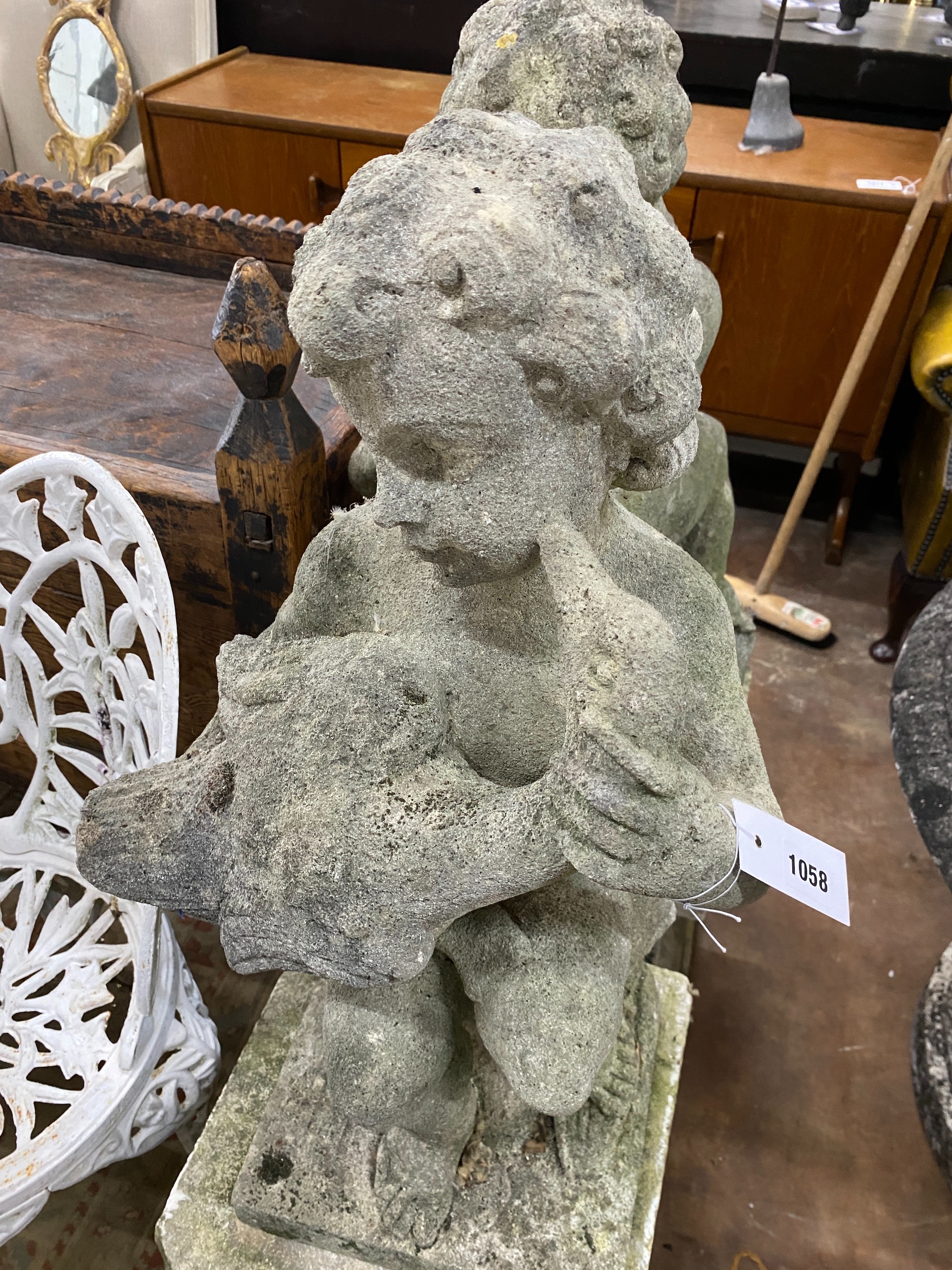 A pair of reconstituted stone cherub and dove garden ornaments on faux marble plinths, height 116cm